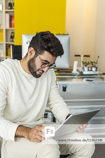Junger Mann mit Laptop in einem modernen Büro