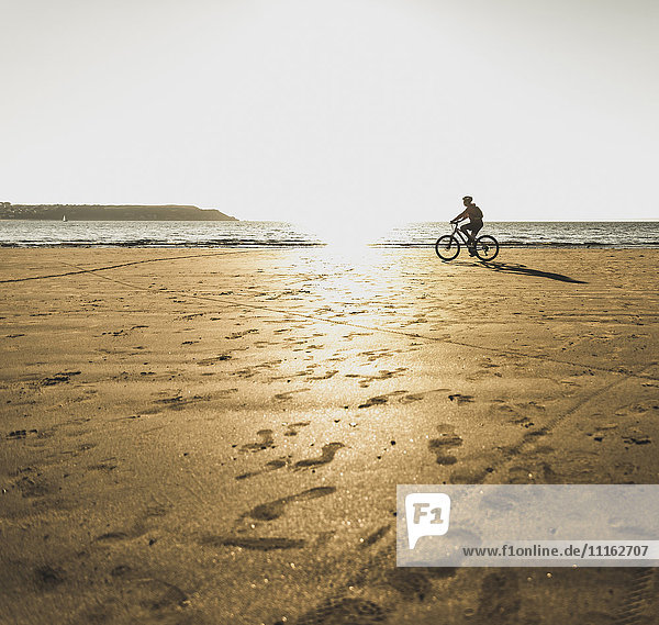 Frankreich  Halbinsel Crozon  Man Biking am Strand