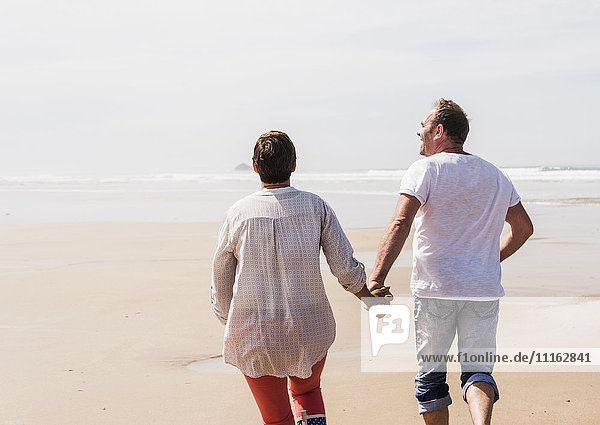 Mature couple running on the beach