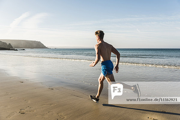 Frankreich  Halbinsel Crozon  junger Mann  der am Strand läuft