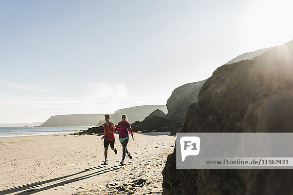 France  Crozon peninsula  young couple running on the beach