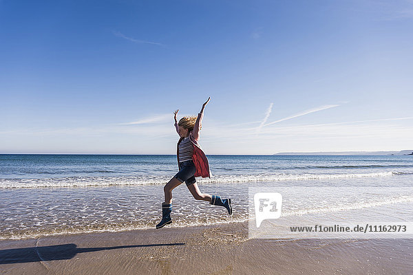 Frankreich  Halbinsel Crozon  Teenager-Mädchen springt vor Freude am Strand