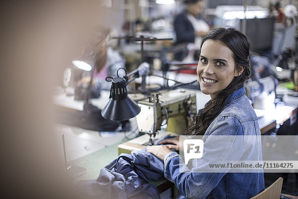 Seamstress in factory sewing clothes