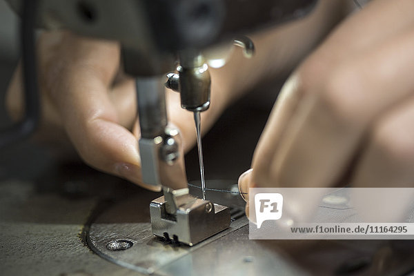 Seamstress working at sewing machine  close up