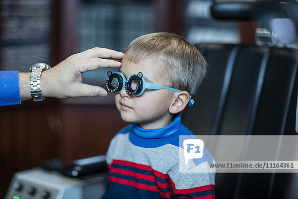 Junge macht Sehtest beim Augenarzt