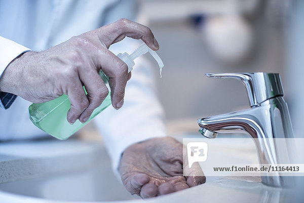 Arzt beim Händewaschen mit Seife