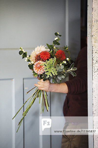 Organic flower arrangements. A woman creating a hand tied bouquet.