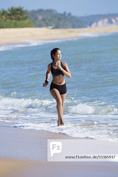 Mixed Race girl running on beach