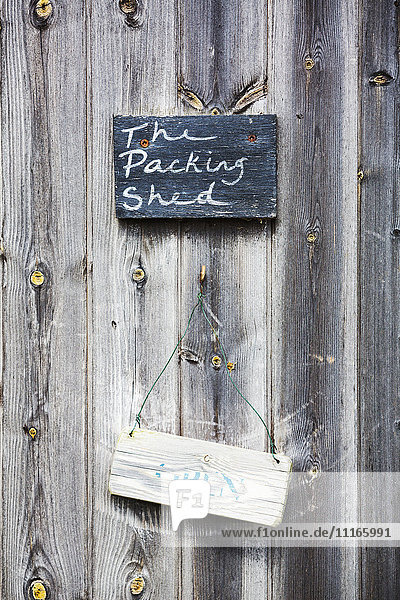 A sign on a wooden door  The Packing Shed.