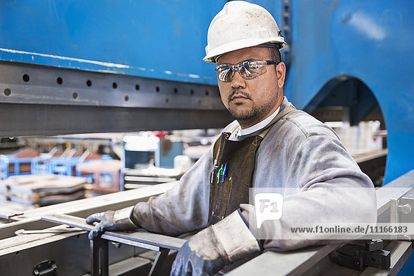 Pacific Islander worker posing in factory
