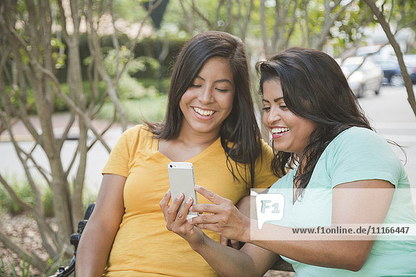 Hispanische Mutter und Tochter posieren für ein Selfie mit dem Handy