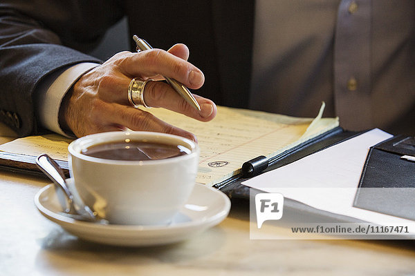 Businessman sitting in a cafe  coffee cup standing on a table.
