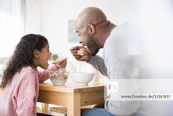 Vater und Tochter essen Müsli am Tisch