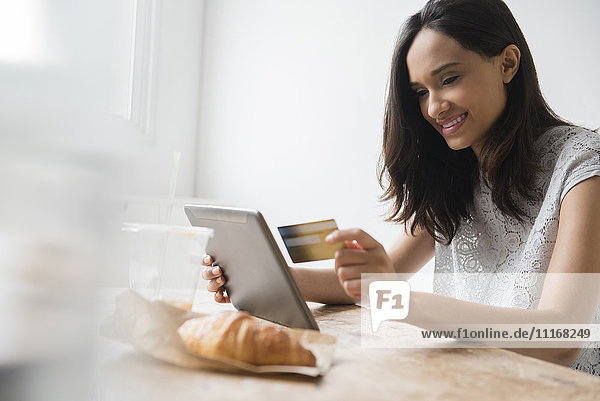 Mixed-Race-Frau beim Online-Shopping mit Kreditkarte