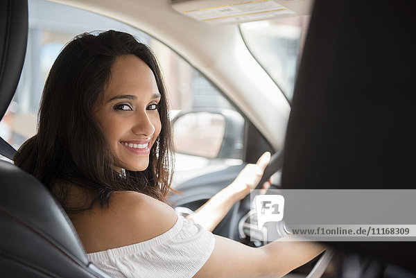 Lächelnde gemischtrassige Frau fährt Auto