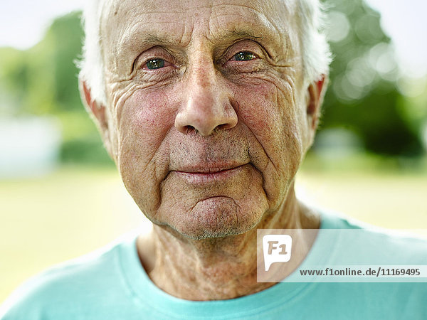 Porträt eines älteren Mannes mit grauen Haaren,  der in die Kamera lächelt.