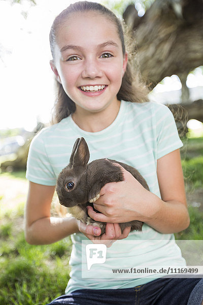 Caucasian girl holding rabbit