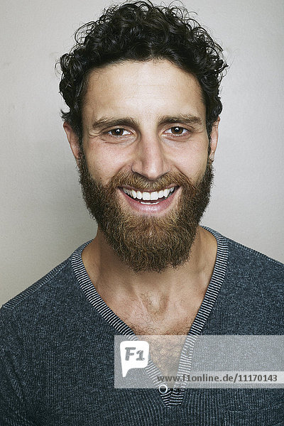 Lächelnder kaukasischer Mann mit Bart  der in die Kamera schaut