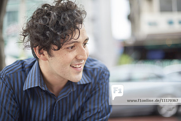 Smiling Hispanic man with curly hair