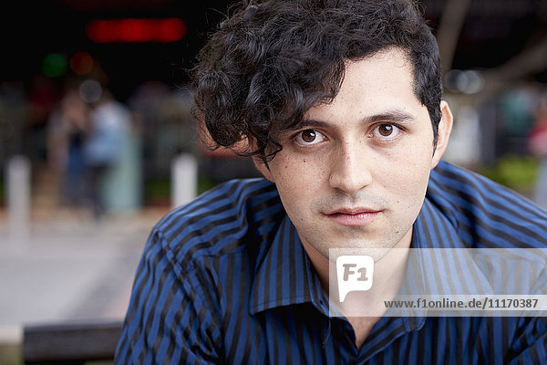 Serious Hispanic man with curly hair