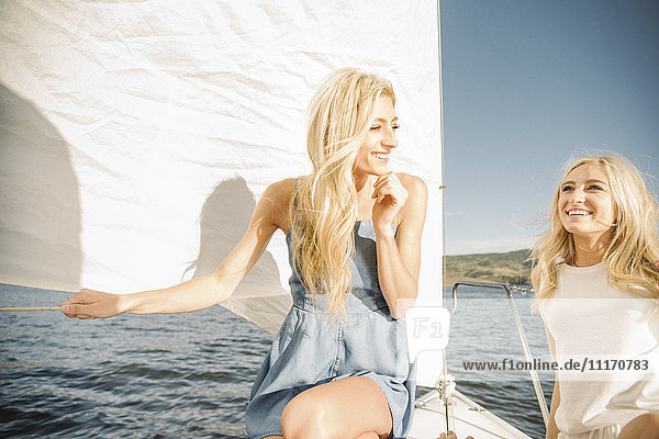 Portrait of two blond sisters on a sail boat.