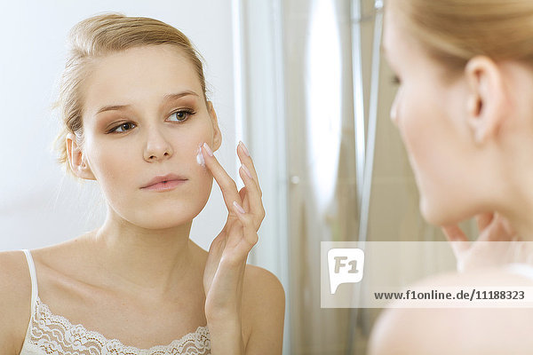 Young woman applying beauty cream  close up