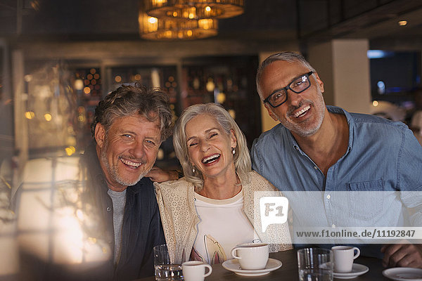 Portrait laughing friends drinking coffee in restaurant