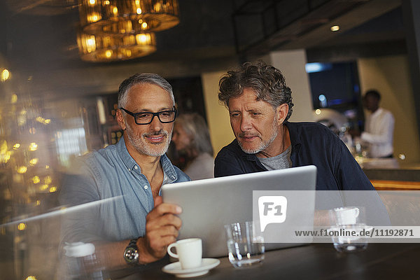 Männer benutzen Laptop im Restaurant