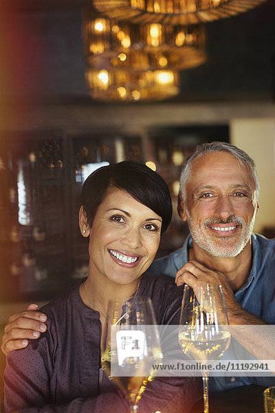 Portrait lächelndes Paar trinkt Weißwein in einer Bar