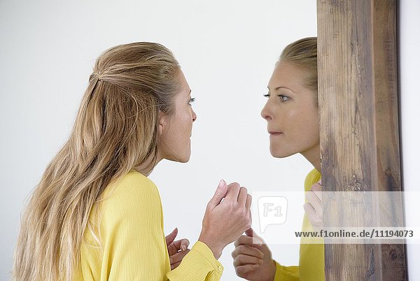 Schöne Frau beim Schminken im Spiegel