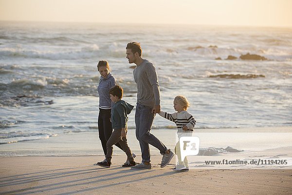 Profil einer Familie  die am Strand spazieren geht