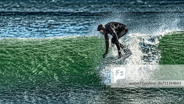 Surfer im Neoprenanzug reitet Welle