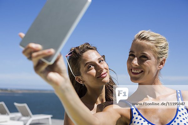 Glückliche Freunde  die Selfie mit einem digitalen Tablett nehmen