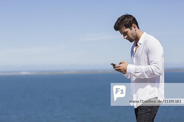Profil eines Mannes mit einem Smartphone