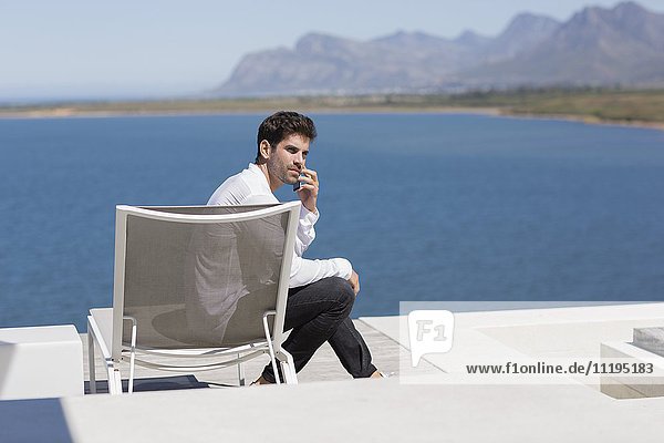 Attractive man sitting on chair and talking on a mobile phone