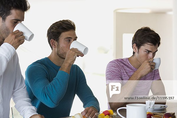 Nahaufnahme von drei Freunden beim Kaffeetrinken