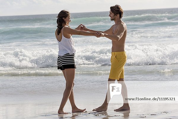 Ein glückliches junges Paar genießt den Strand