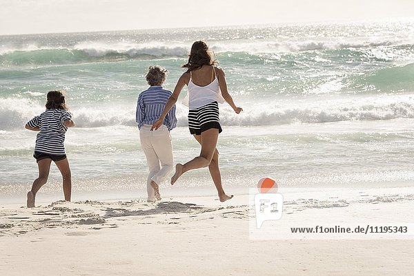 Glückliche Mehrgenerationen-Familie beim Spielen am Strand