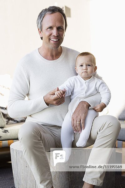 Porträt des glücklichen Vaters mit seiner süßen kleinen Tochter im Wohnzimmer
