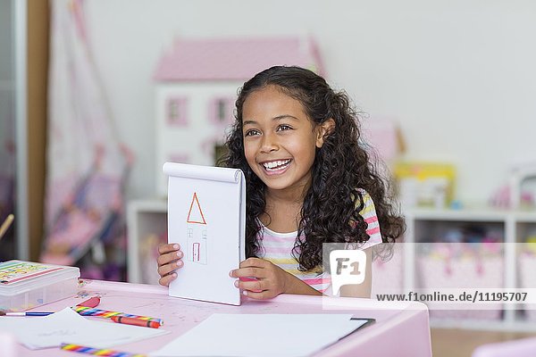 Happy little girl showing her drawing