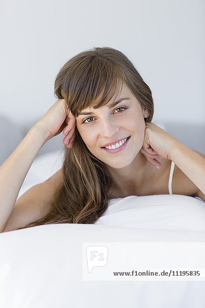 Schöne junge Frau  die sich auf dem Bett entspannt.