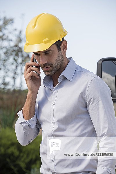 Male engineer talking on a mobile phone at site