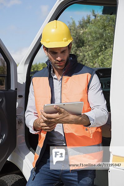 Male engineer using a digital tablet by van