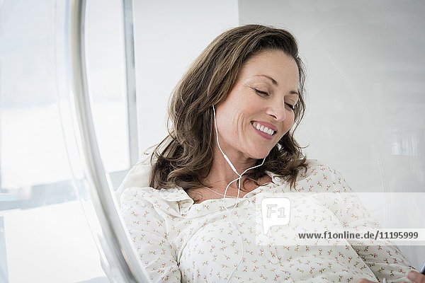 Fröhliche reife Frau beim Musikhören