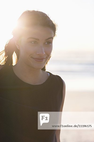 Schöne junge Frau am Strand stehend