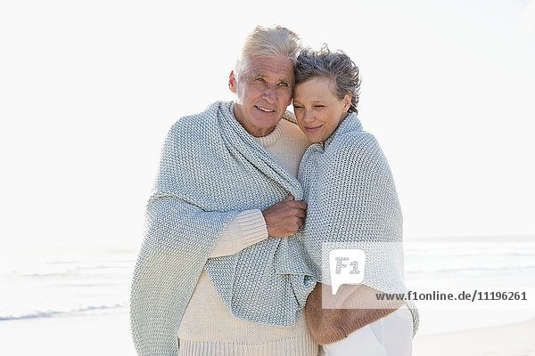 Altes Paar umarmt sich am Strand