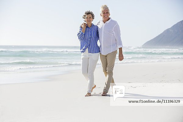 Glückliches Paar  das am Strand spazieren geht