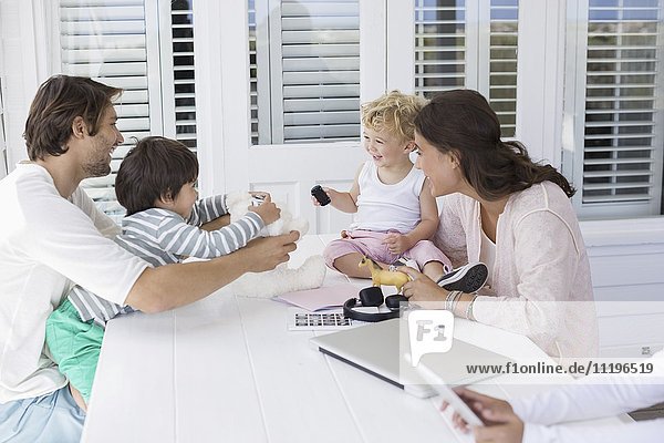Glückliche junge Familie beim Spielen zu Hause