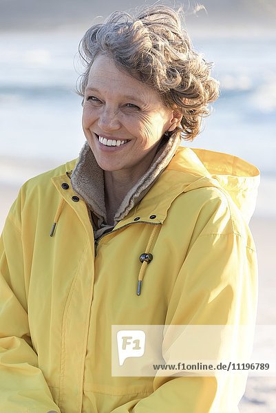 Portrait of happy mature woman smiling on the beach
