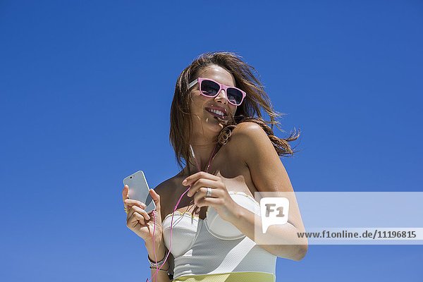 Schöne Frau beim Musikhören mit dem Handy
